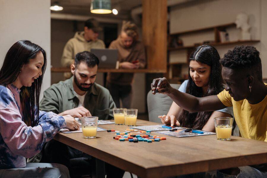 Un grupo alrededor de una mesa larga, creando un juego de mesa.